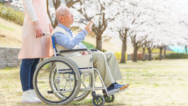 Old man in a wheelchair with his caregiver